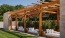 seating areas under wooden cabanas and with nearby lush landscaping