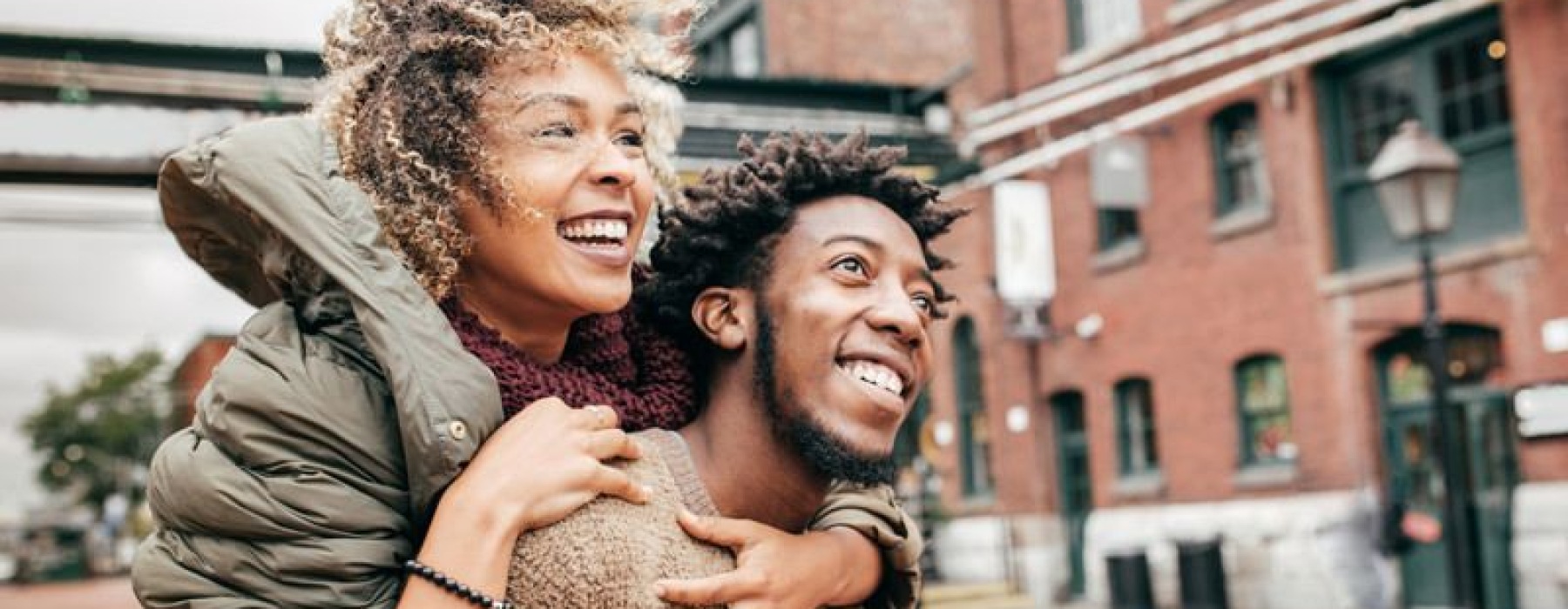 Man and woman walking along a neighborhood street and smiling.